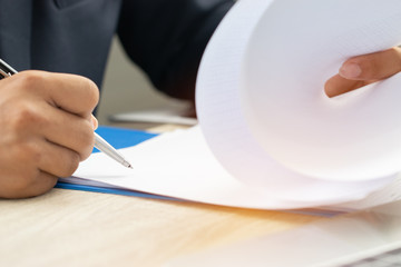 Asian Business man Manager checking and signing applicant filling documents reports papers company application form or registering claim on desk office. Document Report and business busy Concept