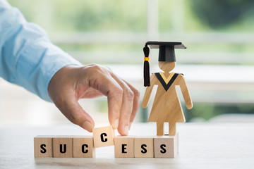 Student hand placing wooden block dominos with letter Success near Sign wood with Graduation...