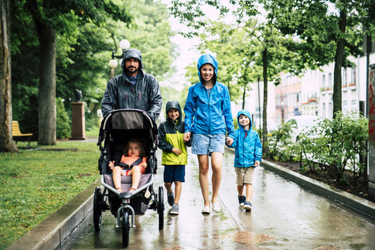 Family With Childs Walk On Rainy Day With Raincoat