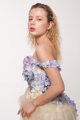 Studio portrait of blooming gorgeous lady in dress of flowers. Fashion concept