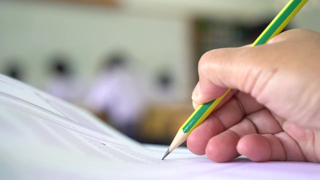 Education students testing exam with pencil drawing selected multiple-choice quizzes or testing exams answer sheets exercises in school, college university classroom