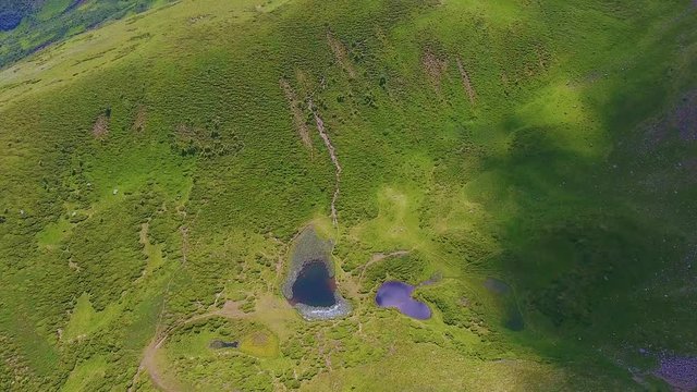 Aerial of a wild green ravine with two tiny ponds in the Carpathians in summer