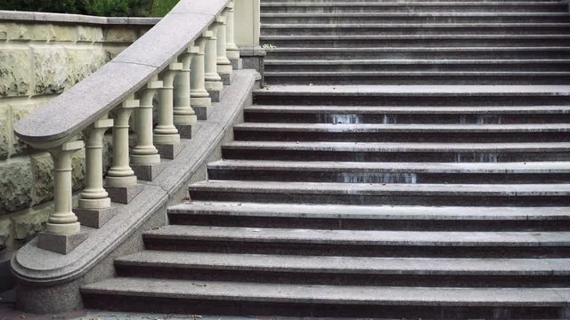 Railing of a stone staircase in the form of columns of antique style. Architecture of the building. Close-up