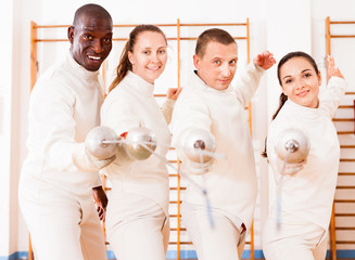 Men and women fencers posing with foils together