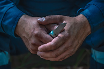 men's hands hold a knife