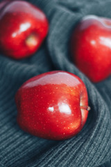 Red apples on gray woolen background