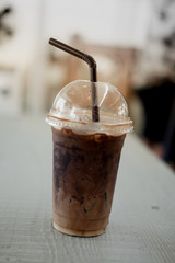 Ice coffee in a glass on wood table