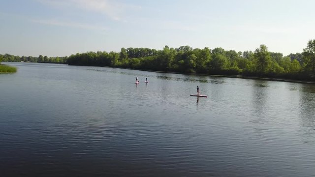 Three young people are kayaking on the river