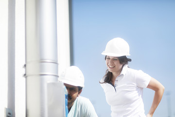 Techniker  mit Helm Paar überprüft Anlage aussen 