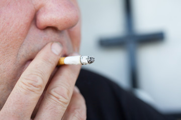 Man smoking a cigarette. Smoke spread.