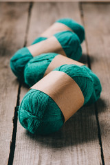 selective focus of wrapped green knitted yarn on wooden background