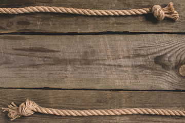 top view of beige knotted nautical rope on wooden background