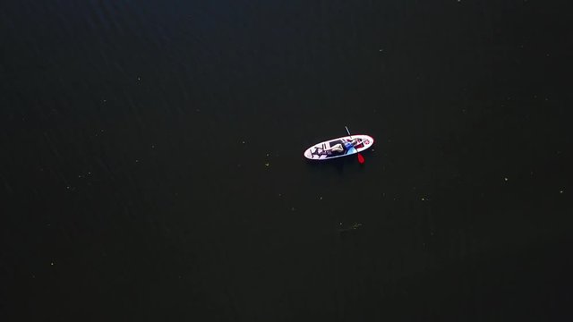 Beautiful young girl lies on the kayak and floats along the river
