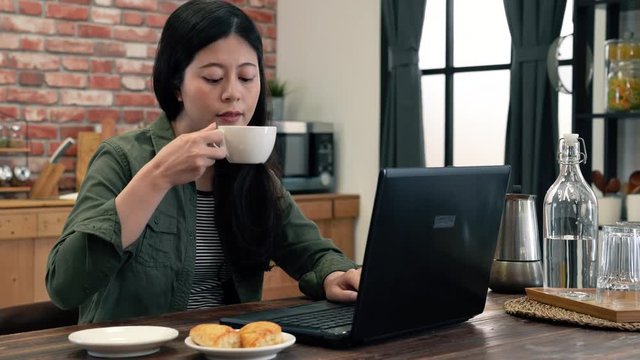 Lady drank coffee and continue on her work.