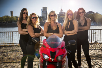 weibliche Motorradfahrerinnen am Flussufer einer Gro&szlig;stadt