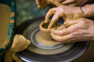 Sculpts in clay pot closeup. Modeling clay close-up. Caucasian man making vessel daytime of white clay in fast moving circle. Art, creativity. Ukraine, cultural traditions. Hobbies