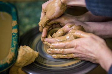 Sculpts in clay pot closeup. Modeling clay close-up. Caucasian man making vessel daytime of white...