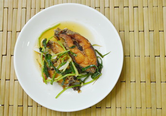deep fried Nile Tilapia or mango fish slice dressing soy sauce and spring onion on plate