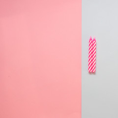 Two pink striped candles for birthday on the pastel colored background. Minimalism. Flat lay.