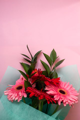 bouquet of pink and red gerberas on a pink pastel background