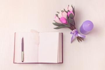 A bouquet of flowers and a book on the table. Blank pages. Toning.