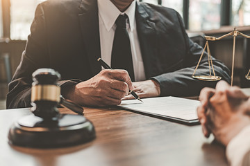 Judge gavel with Justice lawyers having team meeting at law firm background. Concepts of Law and Legal services.