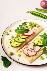 Healthy sandwiches with soft cheese and raw vegetables on crisp bread