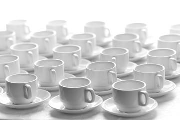 Top view on many stacked in rows of empty clean white cups for tea or coffee. Close-up. Background.