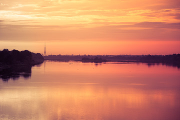 Bright, colorful evening landscape over the river Daugava of pink and purple tones. Dramatic sunset scenery in Latvia, Northern Europe.