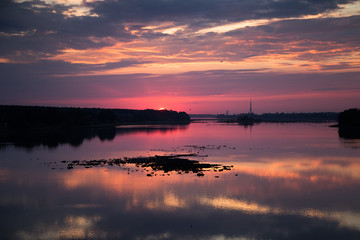 Bright, colorful evening landscape over the river Daugava of pink and purple tones. Dramatic sunset scenery in Latvia, Northern Europe.