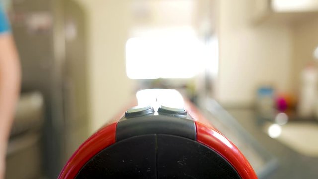 man put a capsule in an espresso coffee maker machine and press the start button