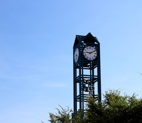 The tall green clock tower with the blue sky background.