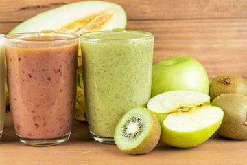 Varied fruit smoothies on wooden background.
