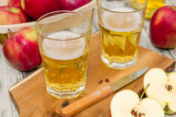 Apple cider and a basket with fresh apples on rustic wooden  background 
