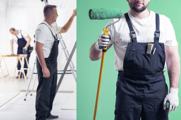 Wall painter in dungarees holding a paint roller on a neo mint green wall background and home...