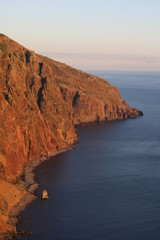 cliffs reflecting the red light of the sunset at the ocean