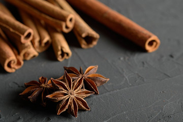 shelves of cinnamon and anise stars in dark colors on a dark concrete stone background