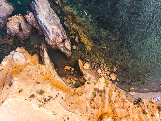 Small rocky secret autentical beach and snorkling swiming people, drone view of beach of Cabo de Palos, Murica, Cartagena, Spain, summer 2018 from drone