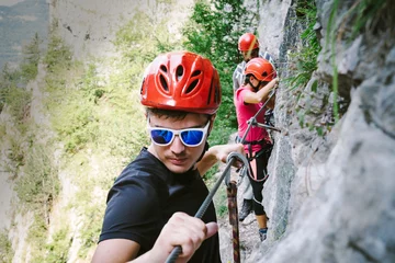 Foto auf Acrylglas Bergsteigen Friends who are climbing along a via ferrata
