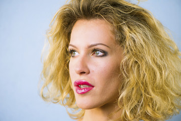 face of a pretty girl with curly hair and red lips closeup