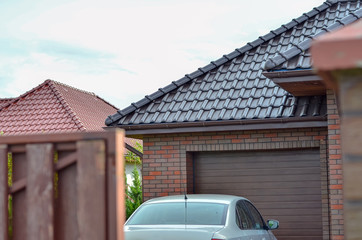 Part of a car parked in front of the garage door