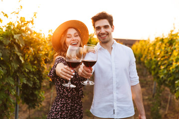 Cute happy loving couple outdoors drinking wine looking camera. - Powered by Adobe