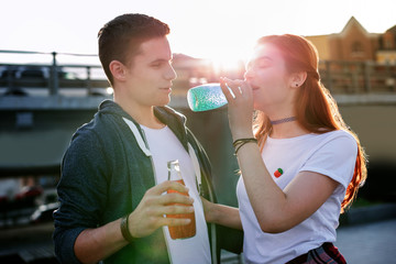 I am thirsty. Pleasant nice woman having a drink while standing together with her boyfriend
