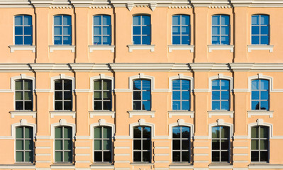Fototapeta na wymiar The yellow facade of the building with windows