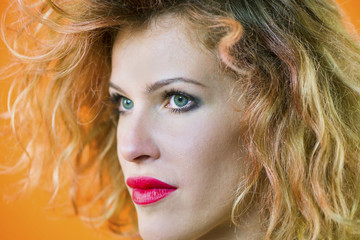 face of a pretty girl with curly hair and red lips closeup
