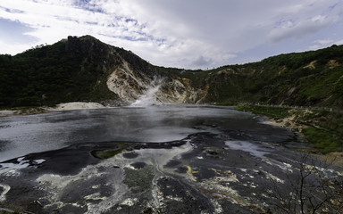 Black ground of lake of hot spring water with smoke