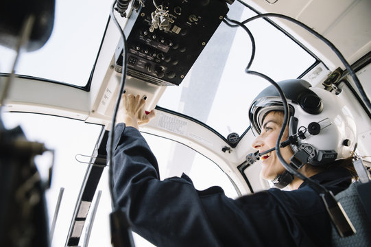 Attractive woman pilot sitting in the helicopter