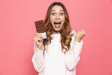 Portrait of an excited young woman holding chocolate