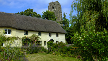 Fototapeta na wymiar St George's Church and Village Cottages in the village of Georgham near Croyde on the North Devon coast AONB, Devon, UK