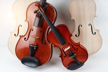 Two violins put in front of raw violin,blurry light around